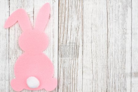 Pink Easter bunny rabbit background on weathered wood