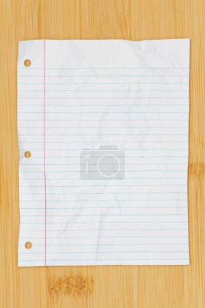Photo for Ruled lined crumpled paper for school isolated a wood desk - Royalty Free Image