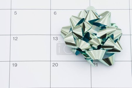 Photo for Teal bow on a calendar for reminders of important dates - Royalty Free Image