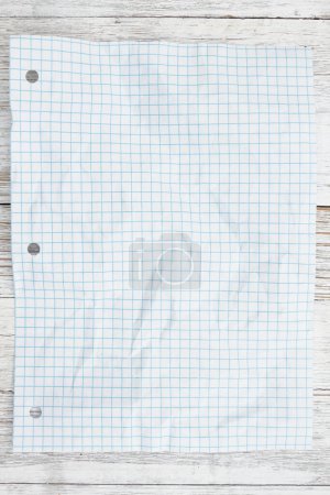 Photo for Ruled lined crumpled graph paper for school on weathered wood desk - Royalty Free Image
