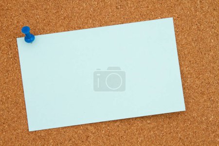 Brown corkboard blue note and pushpin background