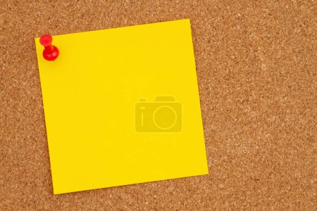 Brown corkboard yellow sticky note and pushpin background