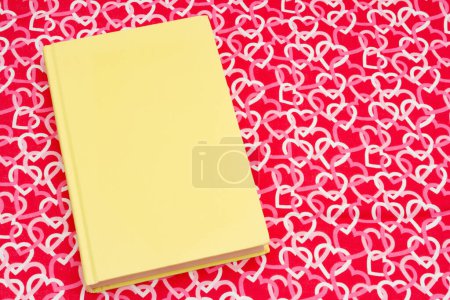 Foto de El amor de la lectura con retro viejo libro amarillo con corazones rojos y blancos - Imagen libre de derechos