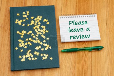 Photo for Please leave a book review with retro old blue book with stars on weathered desk for reading or school - Royalty Free Image