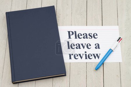 Photo for Please leave a book review with retro old blue book with index card and pen on weathered desk - Royalty Free Image