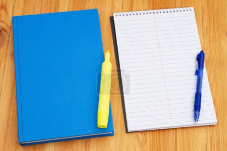 Photo for Retro old blue book on with a notepad and pen weathered desk for taking notes at school - Royalty Free Image