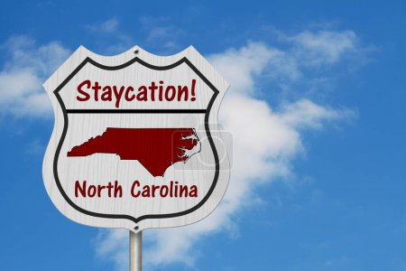 Téléchargez les photos : Caroline du Nord Staycation Highway Sign, Caroline du Nord carte et texte Staycation sur un panneau routier avec fond de ciel - en image libre de droit