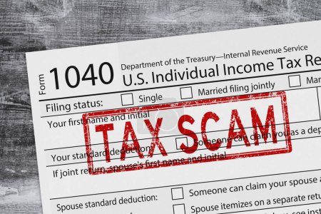 Tax Scam with 1040 tax form us individual income tax on a weathered wood desk