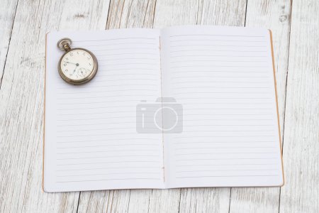 Foto de Hora de planear en bloc de notas negro con reloj en el escritorio - Imagen libre de derechos