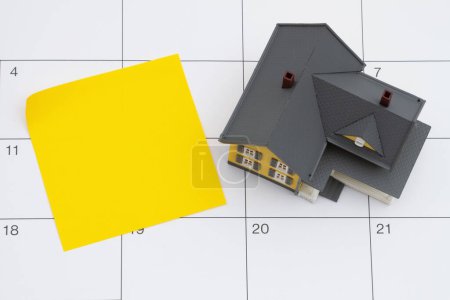 Foto de Pago de hipoteca debido con la casa y la nota adhesiva amarilla en blanco en un calendario - Imagen libre de derechos