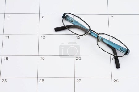 Photo for Time for your eye doctors exam with glasses and sticky note on a calendar - Royalty Free Image