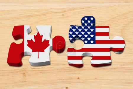 Foto de Relación entre Estados Unidos y Canadá, Dos piezas del rompecabezas con las banderas de Estados Unidos y Canadá sobre madera - Imagen libre de derechos