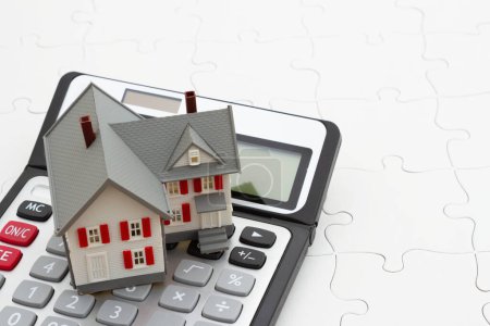 Foto de Un rompecabezas de casa y calculadora para calcular su hipoteca - Imagen libre de derechos