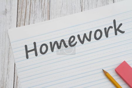 Foto de Mensaje de tarea sobre papel forrado con lápiz para la escuela sobre escritorio de madera envejecida - Imagen libre de derechos