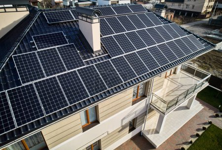 Wohnhaus mit Solarmodulen zur Stromerzeugung durch Photovoltaik-Effekt. Haus mit Solaranlage auf dem Dach. Konzept alternativer Energien und nachhaltiger Energiequellen.