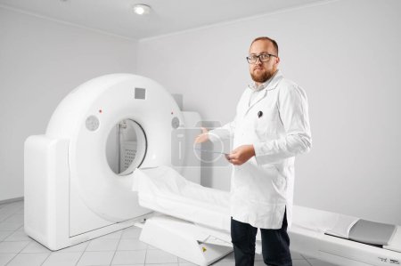 Téléchargez les photos : Portrait de médecin avec tomodensitométrie médicale ou scanner IRM. Radiologiste pointant sur le dispositif d'IRM. Concept de médecine, de soins de santé et de diagnostic moderne. - en image libre de droit