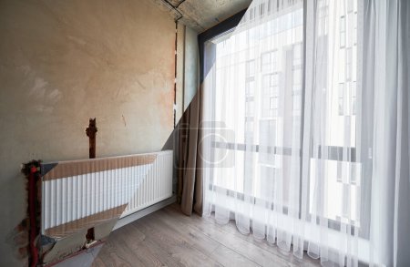 Wohnungsvergleich vor und nach der Sanierung oder Sanierung. Fotocollage aus altem Raum mit großen Fenstern und neuem renovierten Raum mit Heizkörper, Parkettboden und weißen Wänden.