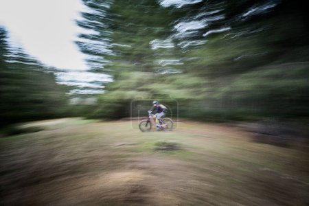 Motion blur. Cyclist man riding electric mountain bike outdoors. Male tourist biking along trail in the forest. Concept of sport, active leisure and nature.