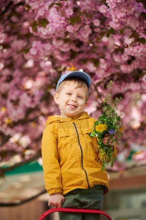 Young boy allergic enjoying after treatment from seasonal allergy at spring. Portrait of happy guy smiling in front of blooming tree at springtime. Spring allergy concept.