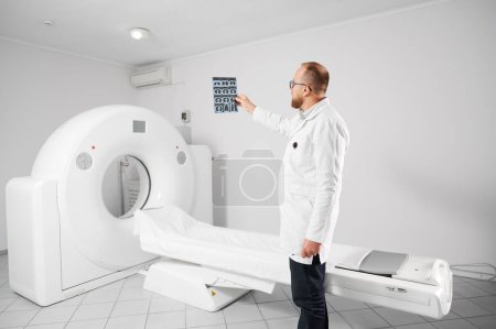 Doctor with medical computed tomography or MRI scanner. Radiologist holding and examining results of MRI. Concept of medicine, healthcare and modern diagnostics.