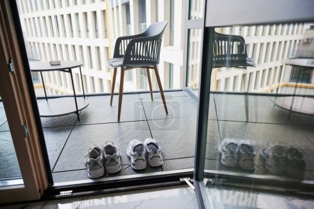 Two pairs of sneakers shoes drying on balcony. Matching white sneakers for man and woman.