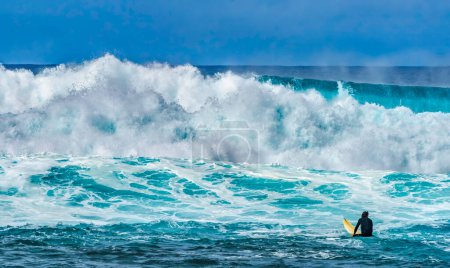 Téléchargez les photos : Surfer Looking Large Wave Waimea Bay North Shore Oahu Hawaii. La baie de Waimea est célèbre pour ses vagues de surf. Ce jour-là, les vagues étaient de 15 à 20 pieds de haut. - en image libre de droit