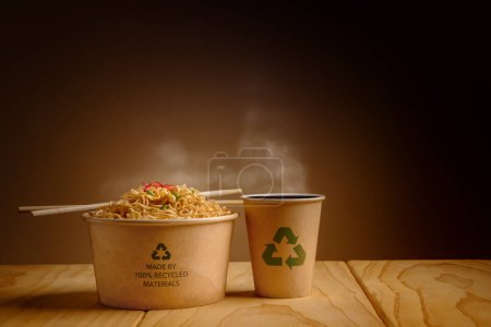 Téléchargez les photos : Concept d'emballage recyclé. Arc recyclé avec nouilles instantanées bouillies chaudes et tasse de café sur la table. Zéro déchet. Protection de l'environnement, réutilisation, renouvelables pour un mode de vie durable - en image libre de droit
