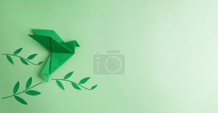 Photo for Peace and New Beginnings of Hope. A Green Dove Flying over green Olive Branch. World International Peace Day. The Concept of a Fluttering Bird that brings Peaceful to the World - Royalty Free Image