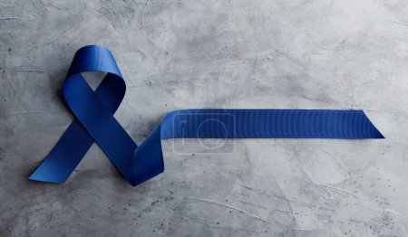 Photo for Prostate Cancer Awareness Campaign Concept. Men Healthcare. Close up of a Blue Ribbon  Lying on Rough Grey Cement Concrete background, Top View - Royalty Free Image