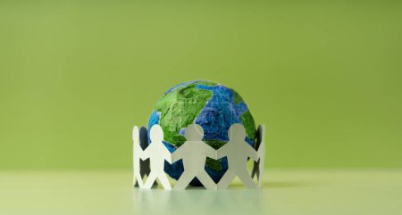 Photo for World Earth Day Concept. Green Energy, ESG, Renewable and Sustainable Resources. Environmental Care. Paper Cut as Group of People  Embracing a Green Globe. Protecting Planet Together. Top View - Royalty Free Image