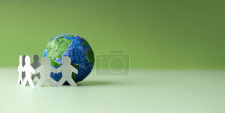 Photo for World Earth Day Concept. Green Energy, ESG, Renewable and Sustainable Resources. Environmental Care. Paper Cut as Group of People  Embracing a Green Globe. Protecting Planet Together. Top View - Royalty Free Image
