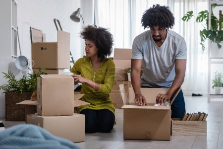 Téléchargez les photos : Couple afro-américain déménageant dans un nouvel appartement - en image libre de droit