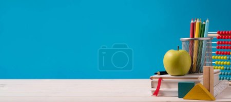 Photo for Back to school concept with apple, books, pencils and stationery on blue background - Royalty Free Image