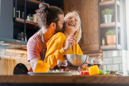 Photo for Young cheerful couple preparing a healthy vegan lunch at home - Royalty Free Image