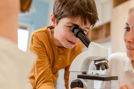 Foto de Niño trabajando con microscopio en laboratorio - Imagen libre de derechos