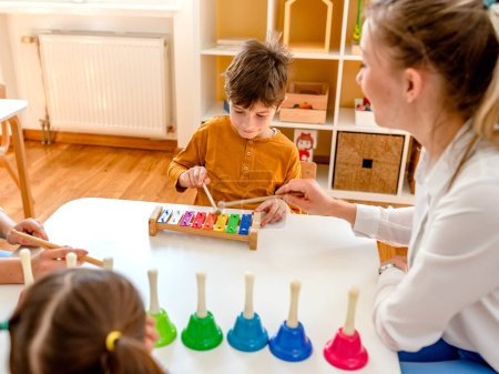Téléchargez les photos : Jardin d'enfants Apprendre la musique en utilisant divers instruments colorés. Apprendre la musique pour les enfants. Montessori Activités musicales pour enfants d'âge préscolaire. - en image libre de droit