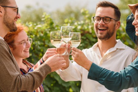 Téléchargez les photos : Amis heureux de boire du vin au vignoble - en image libre de droit