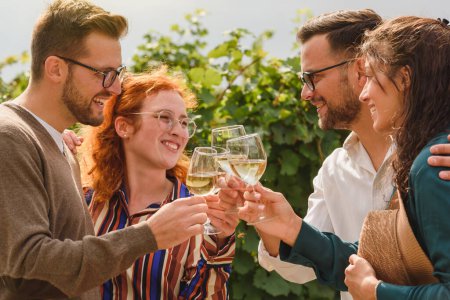 Foto de Amigos felices bebiendo vino en el viñedo - Imagen libre de derechos
