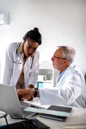 Photo for Male and female doctors consulting looking at a laptop - Royalty Free Image