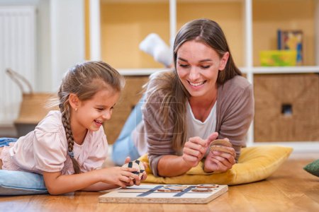 Photo for Mother playing with a child a Tic- Tac-Toe. Educational games for kids. Mother children creative time together. - Royalty Free Image