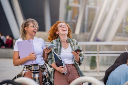 Foto de Un par de estudiantes universitarias alegres frente a la universidad - Imagen libre de derechos