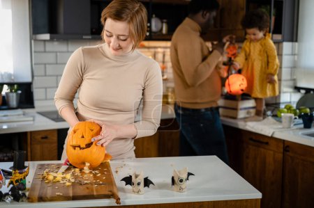 Téléchargez les photos : Heureuse famille multiraciale se préparant à Halloween - en image libre de droit
