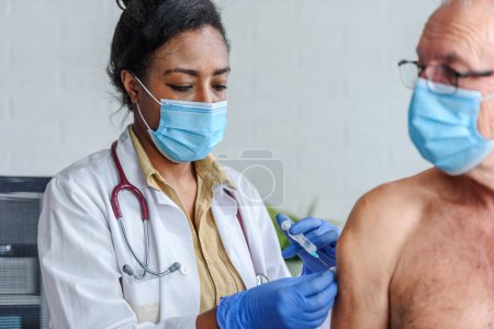 Photo for Medical worker vaccinating an elderly man at the vaccination point. Close up photo. - Royalty Free Image