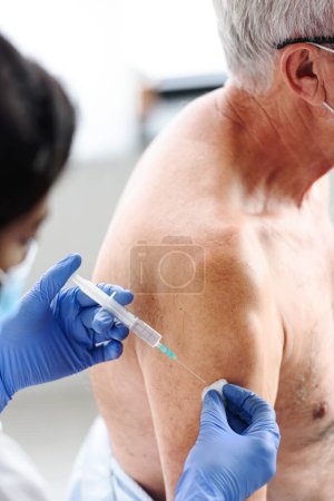 Photo for Medical worker vaccinating an elderly man at the vaccination point. Close up photo. - Royalty Free Image