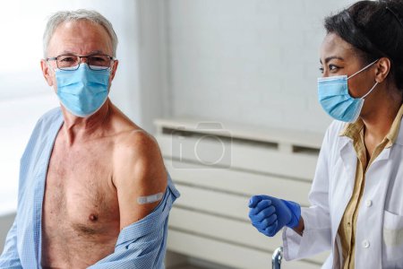 Foto de Trabajador médico vacunando a un anciano en el punto de vacunación. Primer plano foto. - Imagen libre de derechos