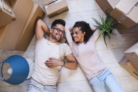 Photo for Young Couple Lying On Floor In Their New House - Royalty Free Image