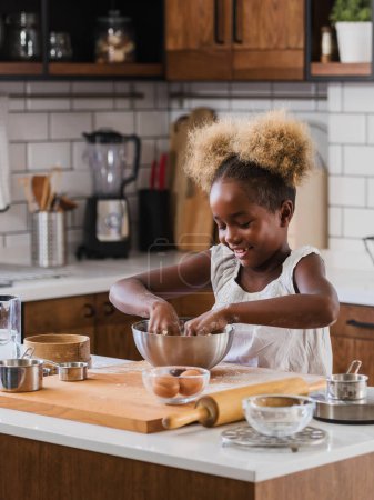 Photo for Cute Little African American Girl Making Cookies at Home Kitchen - Royalty Free Image