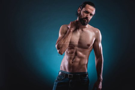Photo for Studio portrait of a beautiful masculine bearded shirtless man showing his abdomen muscles - Royalty Free Image