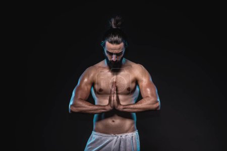 Photo for Studio low key portrait of a powerful muscular man. Abstract conceptual photo o a balancing physical and mental strength. - Royalty Free Image