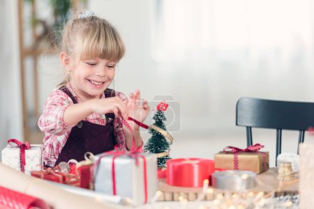 Foto de Niña jugando con decoraciones y regalos de Navidad - Imagen libre de derechos
